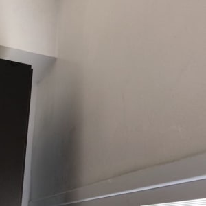 קיר לבן עם סימני לכלוך כהים בפינה