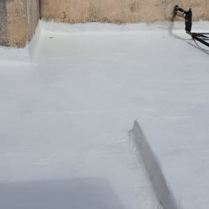 אדם מורח חומר איטום על קיר בטון