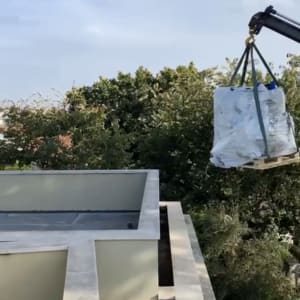 מנוף מרים משטח עטוף מעל גג בניין