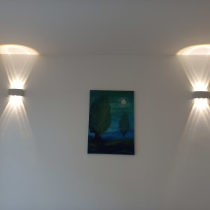 שני גופי תאורה על קיר לבן עם תמונה