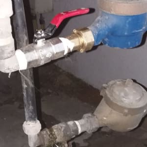 צינור מים עם ברז אדום ומד מים כחול