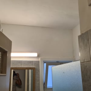 קיר צבוע בלבן עם תאורה עליונה