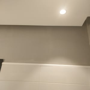 קיר צבוע בגוון אפור עם תאורה עליונה