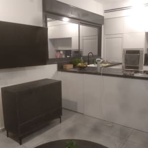 מטבח מודרני עם ארונות לבנים ומשטח עבודה שחור