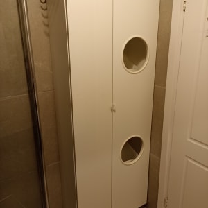 ארון לבן עם ידיות עגולות בחדר אמבטיה