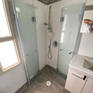 מקלחת עם דלתות זכוכית וברז גשם