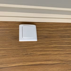 מתג חשמלי לבן על קיר עץ