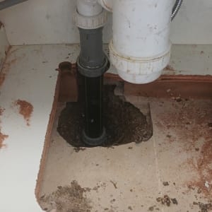 צנרת פלסטיק מתחת לכיור עם סימני חלודה