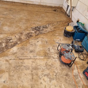 חוטי חשמל וכלי עבודה על רצפה מוכתמת