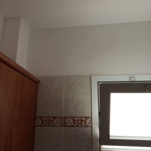 קיר צבוע בלבן ליד חלון קטן