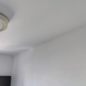 קיר ותקרה צבועים בלבן עם מנורה עגולה