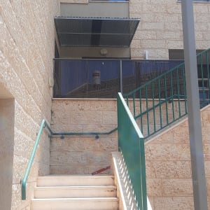 סוכך מתכת מעל מרפסת בקומה עליונה