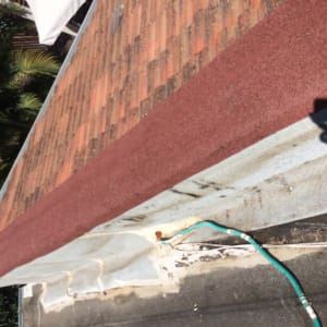 גג רעפים עם קצה אדום וצינור ירוק