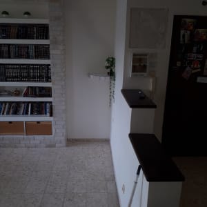 קיר לבן עם סימני טיח, מקל צביעה על הרצפה