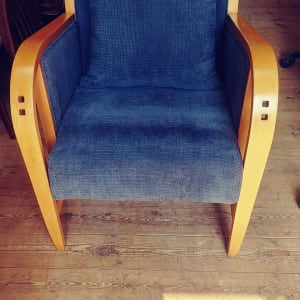 כורסה עם ריפוד כחול ומסגרת עץ בהירה