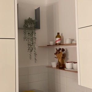 מדף עם בקבוק וכלים במטבח, מכונת קפה על השיש