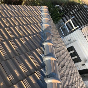 רעפים חומים על גג עם איטום אפור