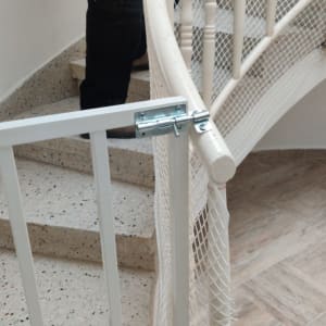 שער בטיחות לבן מותקן על מדרגות עם רשת הגנה