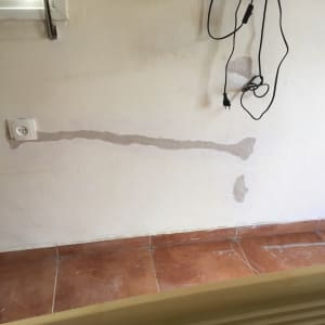 שקע חשמל בקיר עם חוטים תלויים