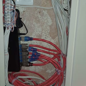 ארון תקשורת עם כבלים אדומים ולבנים מחוברים למפצל