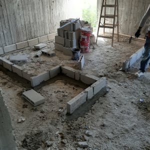 קירות בטון, בלוקים, סולם ודלי באתר בנייה