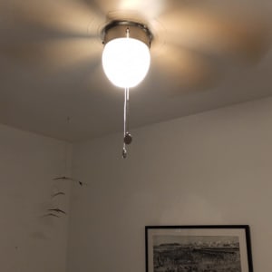 מאוורר תקרה עם מנורה דולקת וחוט משיכה