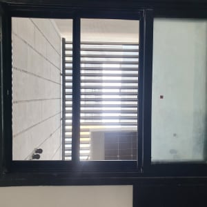 חלון אלומיניום עם מסגרת שחורה ותריסים