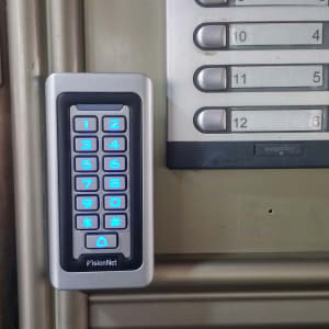 לוח מקשים מואר ליד פאנל אינטרקום עם מספרים