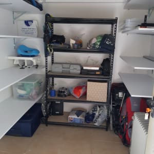 מדפים עם קופסאות אחסון, תיקי גב וציוד ארגוני