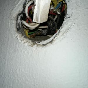 חוטי חשמל צבעוניים יוצאים מקיר