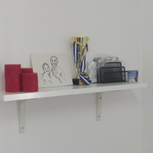 מדף לבן עם תומך מתכת על קיר לבן