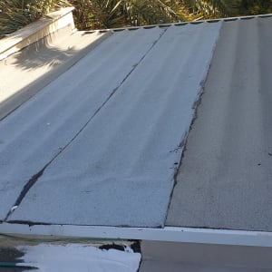 גג עם יריעות איטום אפורות וסדקים קטנים