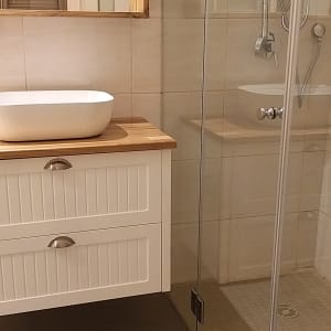 מקלחון זכוכית עם ראש מקלחת וכיור לבן