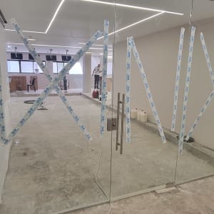 דלת זכוכית עם סרטי הדבקה בצורת איקס