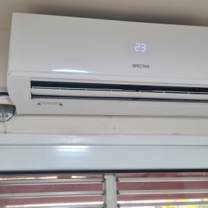 מזגן מותקן על קיר עם תצוגת טמפרטורה 23 מעלות