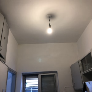 תקרה צבועה בלבן עם נורה תלויה במרכז