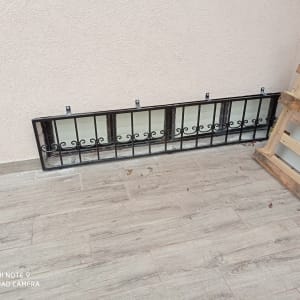 מסגרת מתכת שחורה עם עיטורים על רצפה אפורה