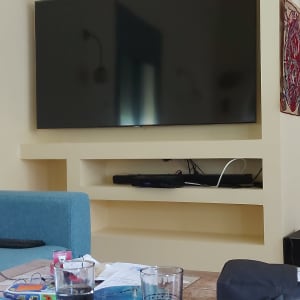 טלוויזיה תלויה על קיר גבס עם מדפים