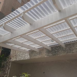 פרגולה מעץ עם גג פלסטיק שקוף בגינה