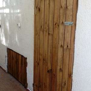 דלת עץ חומה עם מנעול על קיר לבן