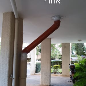 צינור כתום מחובר לתקרה עם איטום לבן