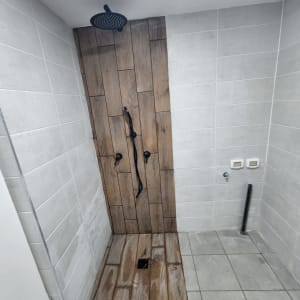 מקלחת עם אריחים חדשים וברזים מותקנים