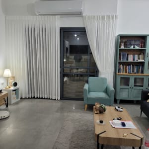 וילון לבן תלוי על חלון זכוכית בסלון מודרני