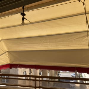 סוכך בד לבן עם שוליים אדומים במרפסת