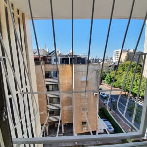 נוף עירוני מבעד לסורגים עם בניינים ורחוב