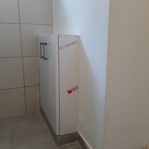 ארון לבן עם ידיות מתכת בפינת חדר