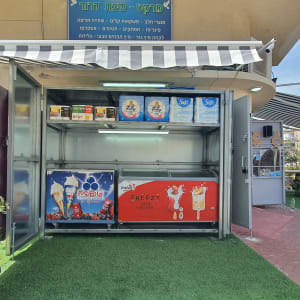 מקרר פתוח עם מוצרים, שלט חנות, אדם עומד ליד.