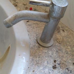 ברז מלוכלך עם כתמים על הכיור