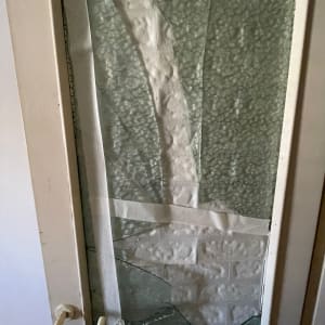 זכוכית שבורה עם סרט דבק על דלת