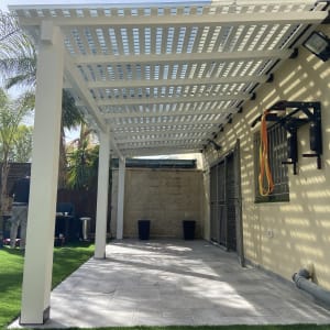 פרגולה לבנה מעץ בחצר עם דשא סינתטי